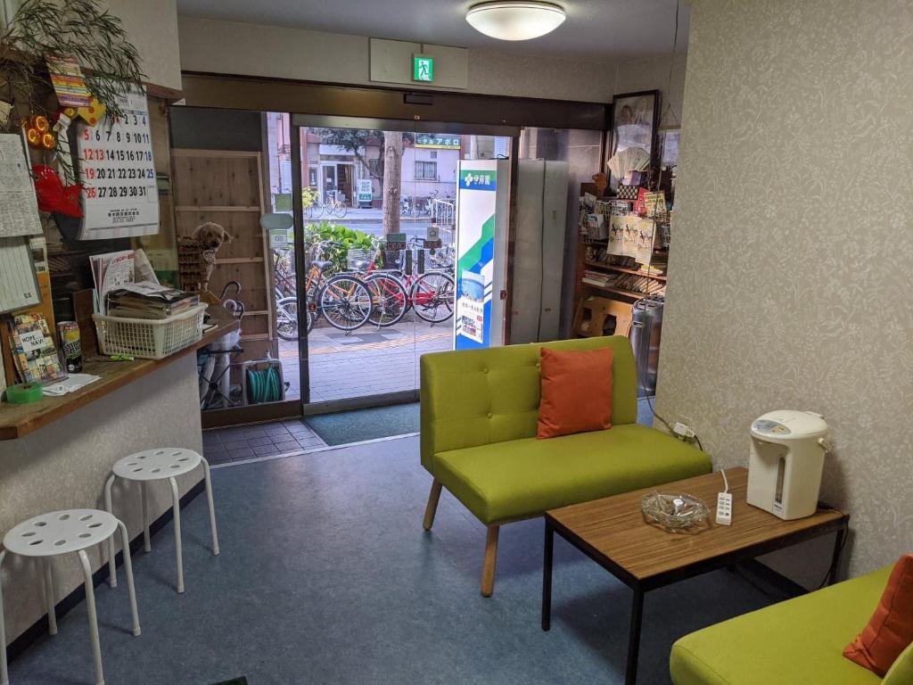 ein Zimmer mit einem grünen Stuhl und einem Tisch in einem Geschäft in der Unterkunft Hotel Diamond in Osaka