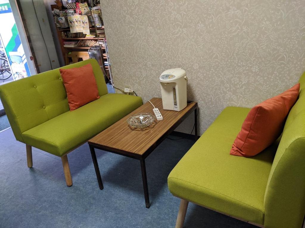 two green chairs and a table in a store at Hotel Diamond in Osaka