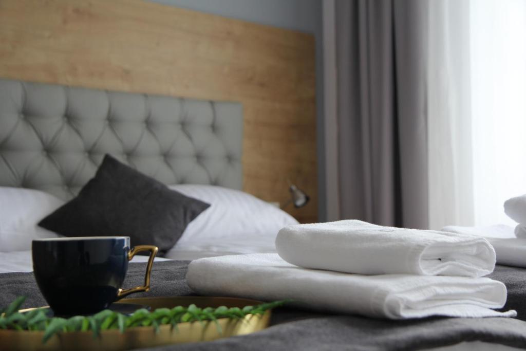 Una cama con toallas y una taza de café. en Apartamenty Głębce 75 en Wisła