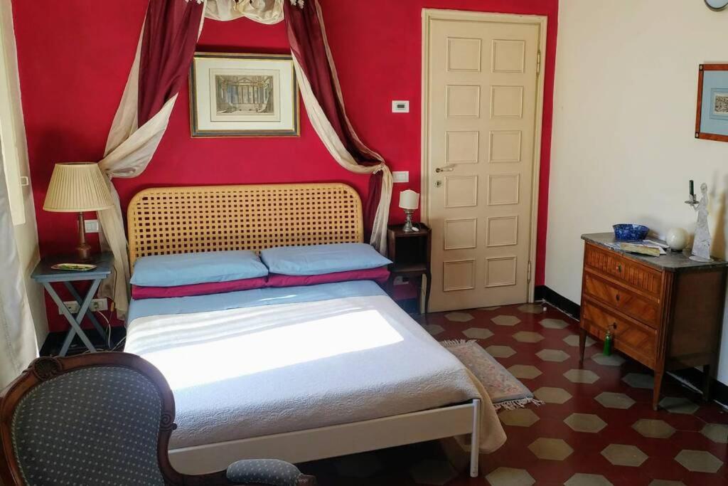 1 dormitorio con cama y pared roja en Cozy apartment in Palazzo Malaspina, en Piacenza