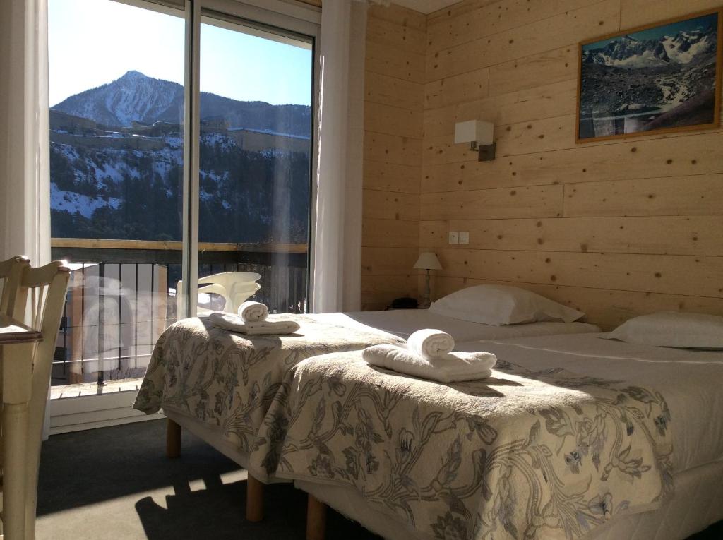 a bedroom with a bed with a view of a mountain at Hôtel Cristol in Briançon