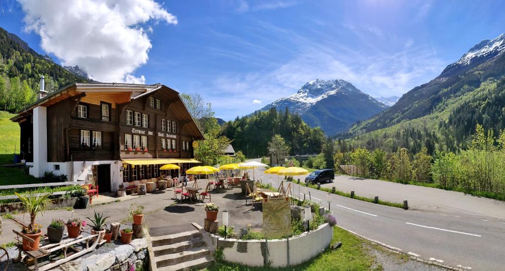 a building with tables and umbrellas on the side of a road at "Terrasse" Nessental in Gadmen