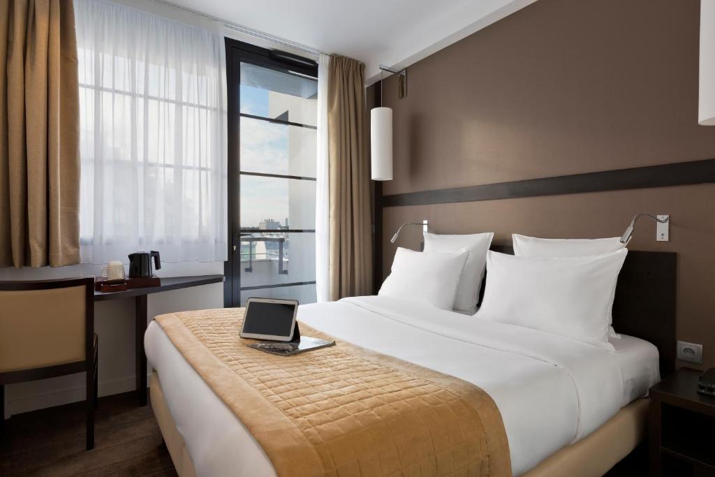um quarto de hotel com uma cama com um computador portátil em Simon's Boutique Hôtel em Paris