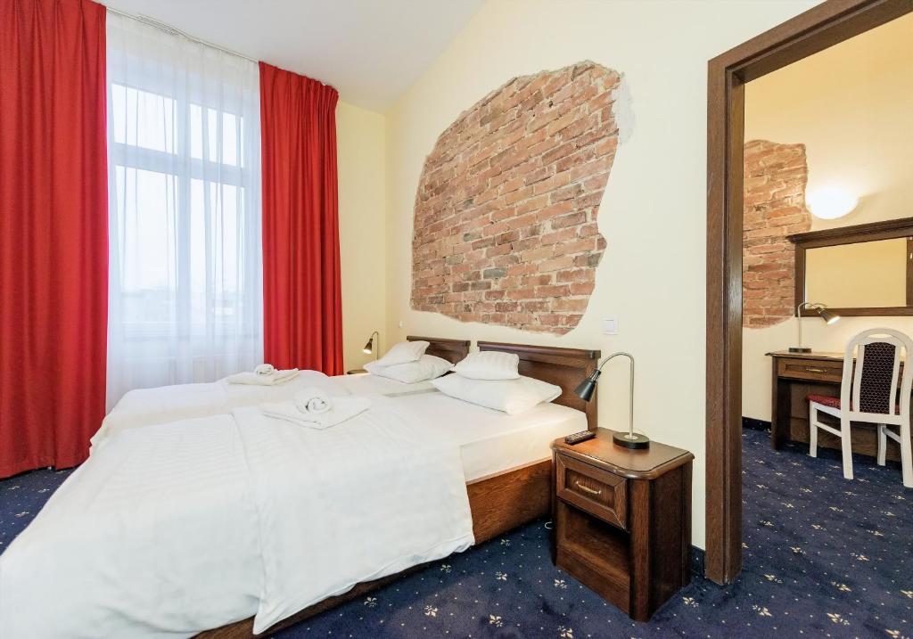 Pokój hotelowy z łóżkiem i lustrem w obiekcie Hotel Marczewski w Bielsku Białej