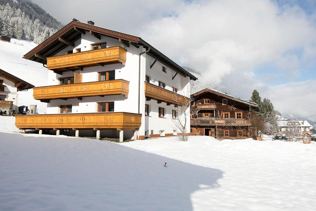 un edificio con balcones de madera en la nieve en Appartement Zill, en Tux