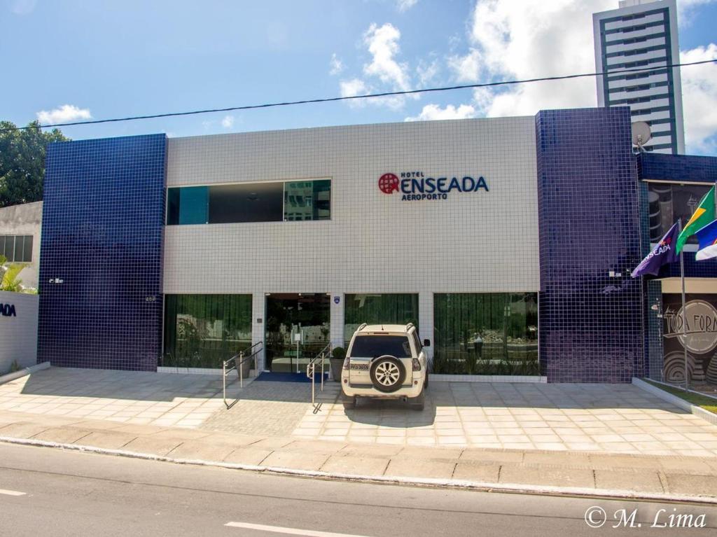 a car parked in front of a building at Hotel Enseada Aeroporto in Recife