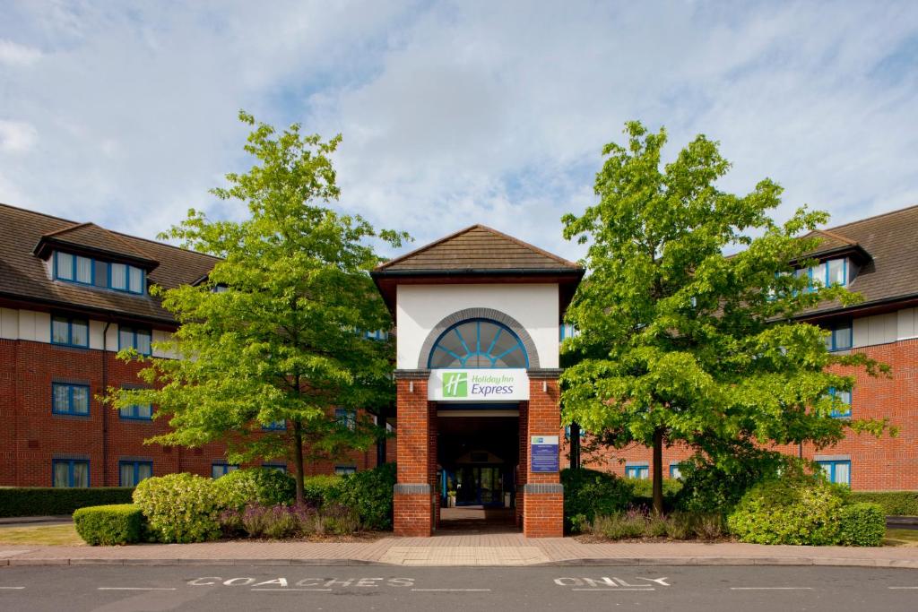 un bâtiment avec un panneau devant lui dans l'établissement Holiday Inn Express Birmingham NEC, an IHG Hotel, à Bickenhill