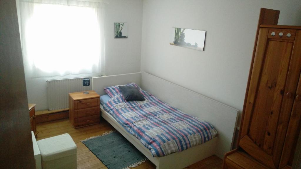een kleine slaapkamer met een bed en een raam bij Pension Wiesental in Wiesental