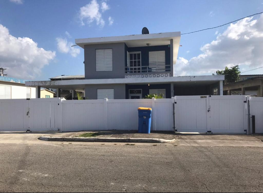 una cerca blanca frente a una casa en Tropical Getaway en Aguadilla