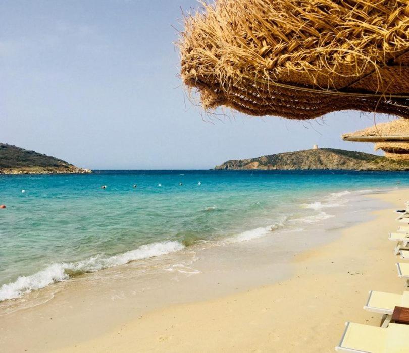 - une plage avec des chaises, un parasol et l'océan dans l'établissement Appartamenti Via La Marmora, à Teulada