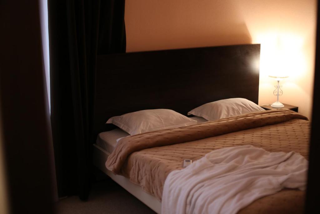 Okhtyrka的住宿－Готель "Палац"，一间卧室设有两张床和一张桌子上的台灯。
