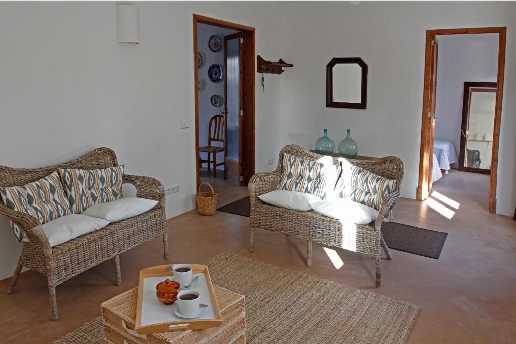a living room with two chairs and a table at Casa Mediterranea en pueblo de mar in Cala Figuera