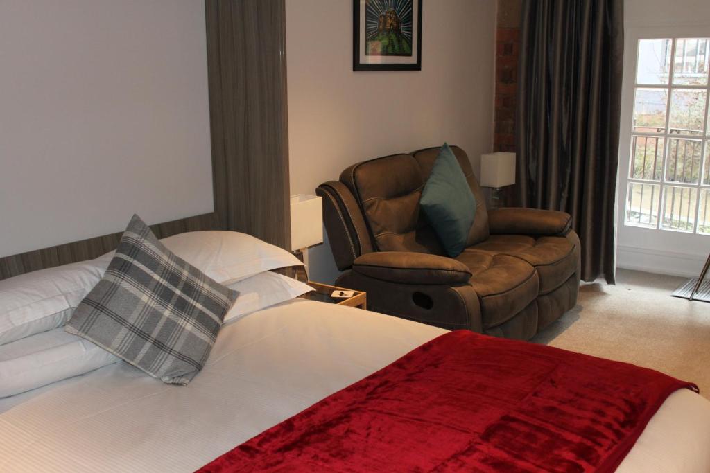 Habitación de hotel con cama y silla en Waters Edge at Cocoa Suites, en York