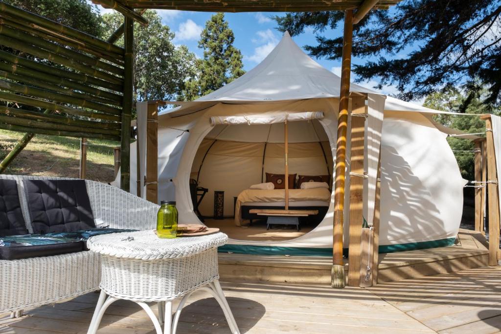 a tent with a bed in it on a patio at Kerikeri Glamping in Kerikeri