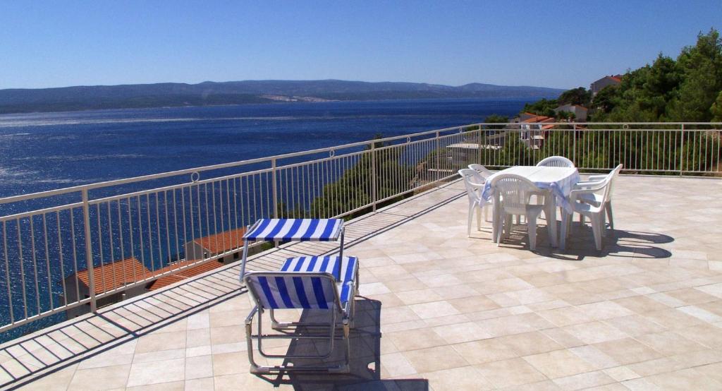 a balcony with a table and chairs and the water at Apartments Peka in Marusici 