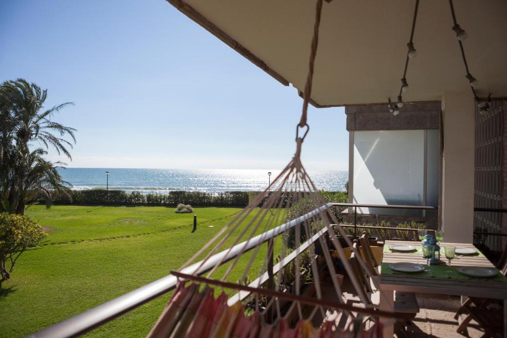 d'un balcon avec un hamac et une vue sur l'océan. dans l'établissement Gavamar Castelldefels Beachfront Apartment- Direct access to the beach, à Gavà