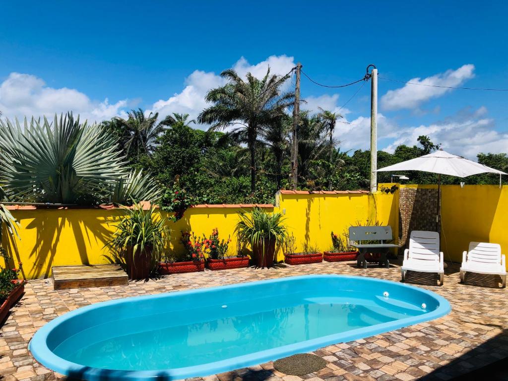 a swimming pool in a yard with a yellow fence at Casa Amarela na praia para 13 pessoas in Ilhéus