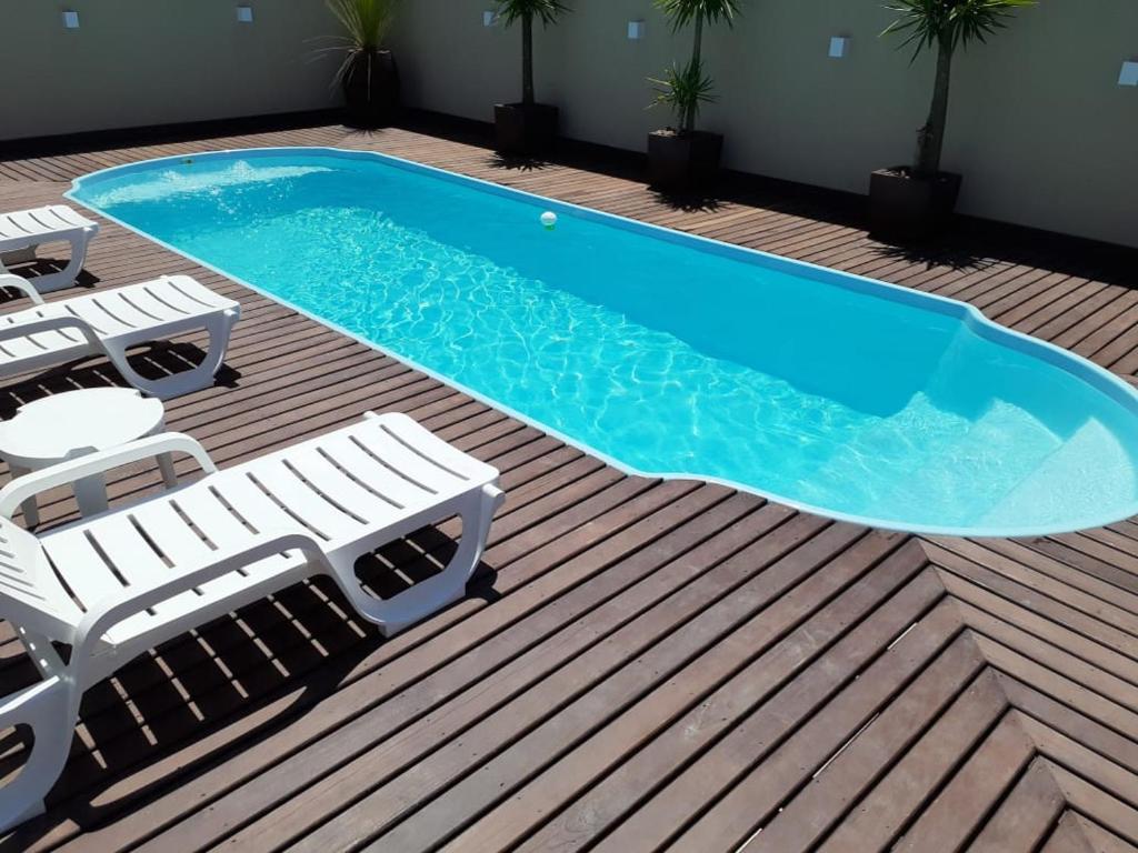 une piscine avec deux chaises longues et une piscine dans l'établissement CASA AMBAR COM PISCINA EM Mariscal N 705, à Canto Grande
