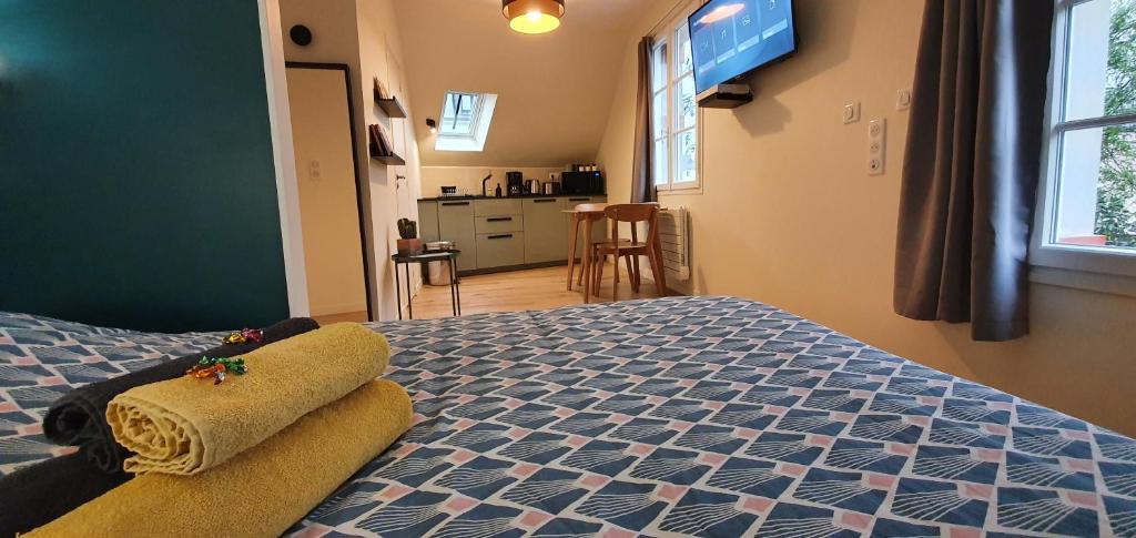 sypialnia z łóżkiem z niebiesko-białą narzutą w obiekcie Appartement Studio Prieuré w mieście Quimper