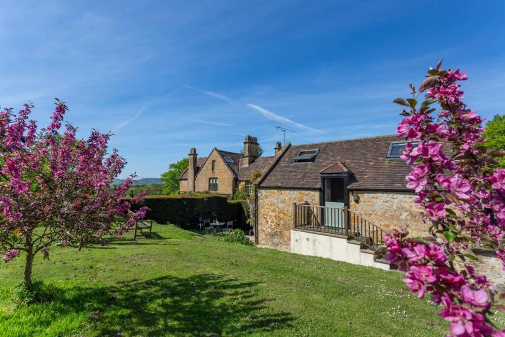 ブリッドポートにあるThe Apple Loftの庭のピンクの花々が咲く石造りの家