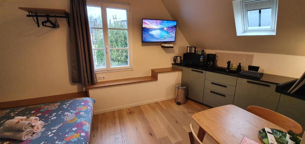 a kitchen with a table and a tv on the wall at Appartement Studio Chanoine in Quimper