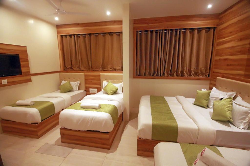 Cette chambre comprend 2 lits et une télévision. dans l'établissement Hotel Al Madina palace, à Mumbai