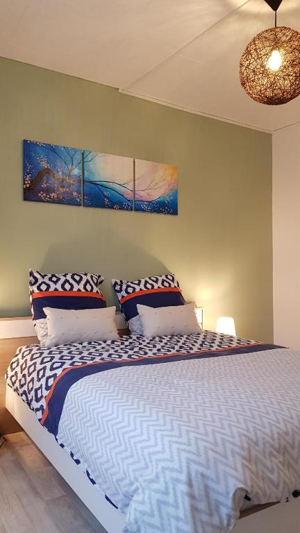 une chambre avec un grand lit avec des oreillers dans l'établissement Gite D'Elnon-Libre, à Saint-Amand-les-Eaux