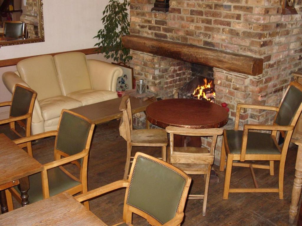 sala de estar con mesa, sillas y chimenea en Chichester Inn, en Chichester