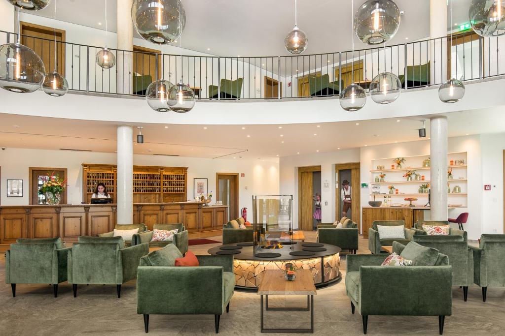 eine Lobby mit Sofas, Stühlen und einem Tisch in der Unterkunft Hotel Obermaier in München
