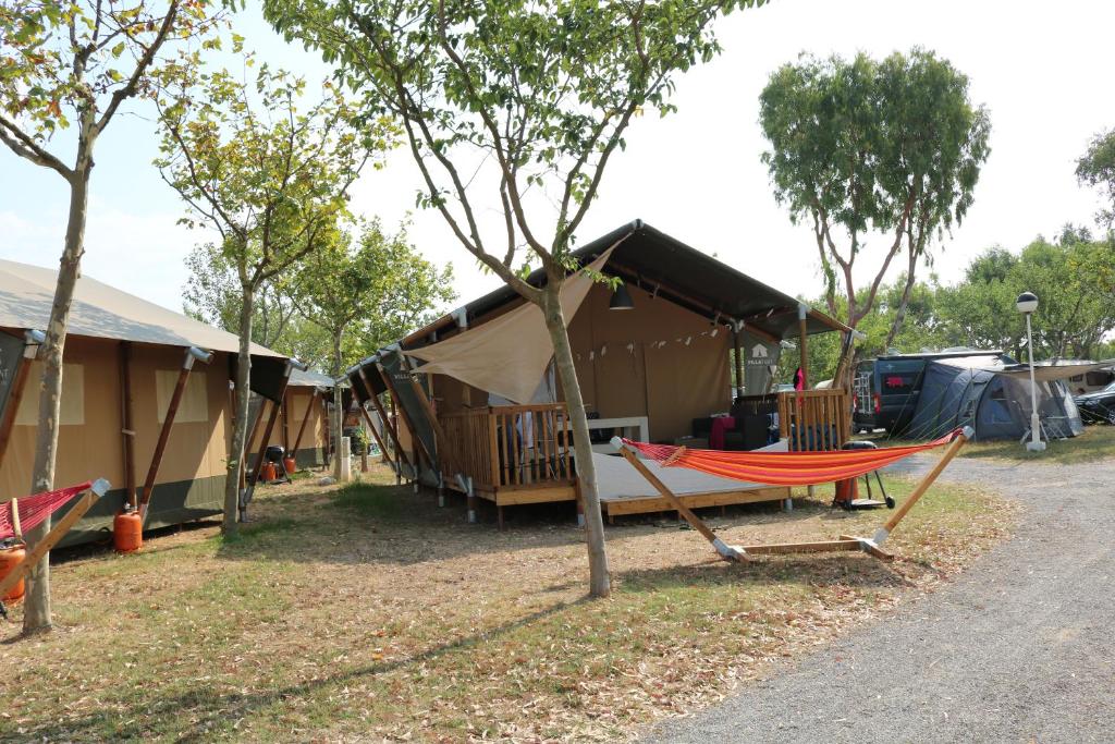 a couple of tents with a hammock in front of it at Glamping Costa Brava in Fortiá