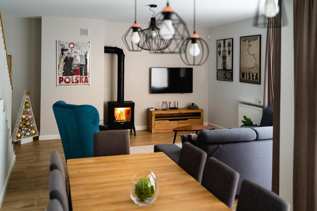 a living room with a dining table and a fireplace at Apartamenty Wczasowa in Szczyrk