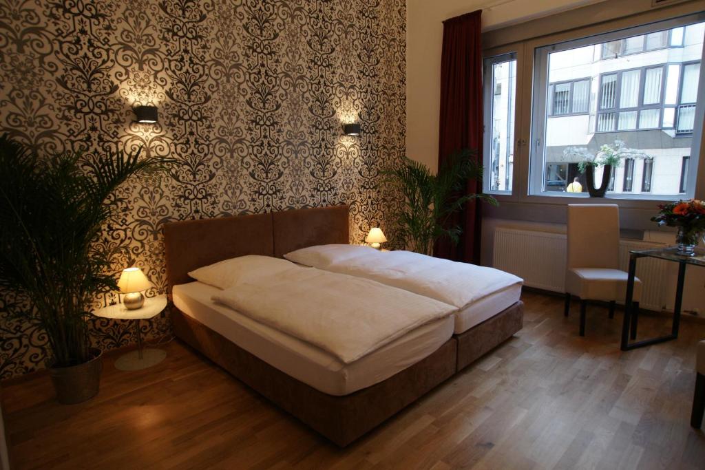 1 dormitorio con cama, mesa y ventana en Hotel Stern, en Düsseldorf