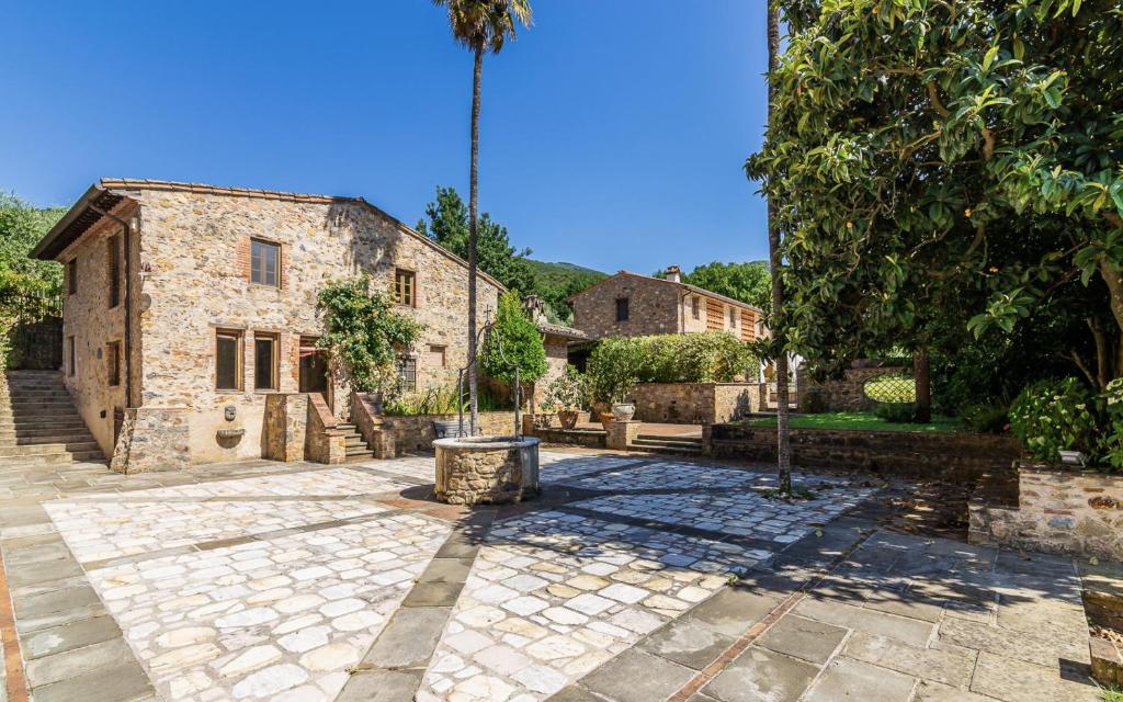 un patio de un antiguo edificio de piedra con una palmera en Dependance Villa Il Poderino, en Santa Maria del Giudice