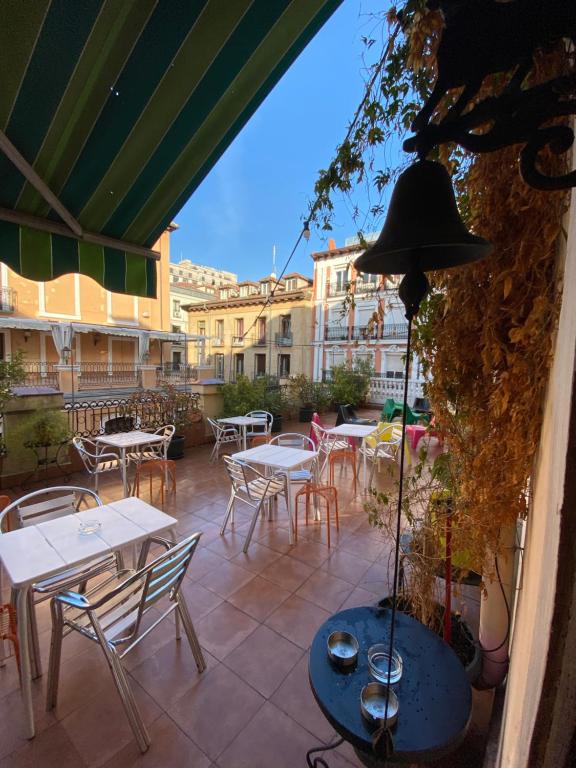 un patio con mesas, sillas, mesas y edificios en Barbieri Sol Hostel en Madrid