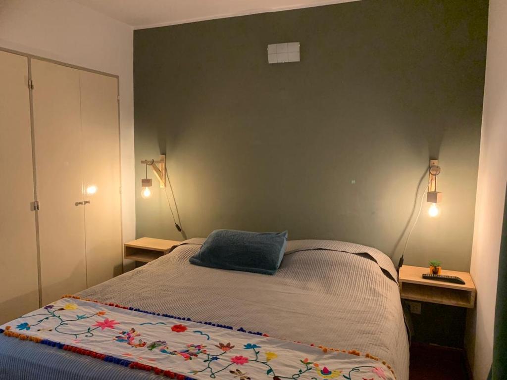 Un dormitorio con una cama con una almohada azul. en Lujoso Dpto en Zona Norte en Salta