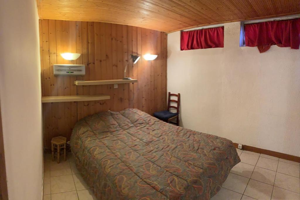a bedroom with a bed in a room with wooden walls at Boost Your Immo Vars Le Schuss 268 in Vars