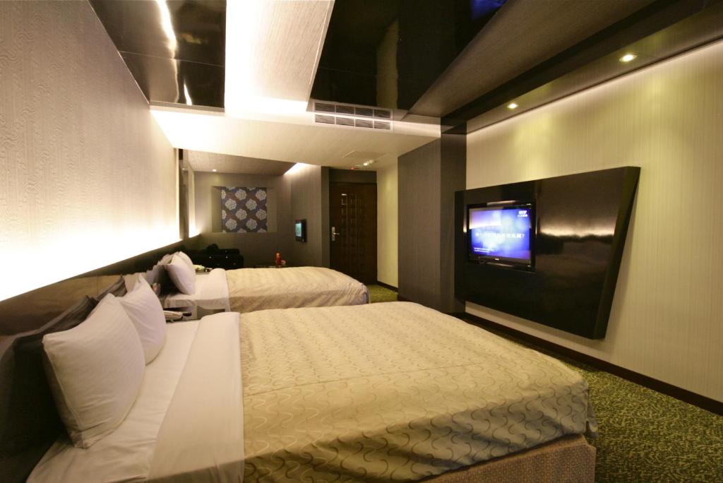 a hotel room with two beds and a tv at Fairy Tale City Motel in Hualien City