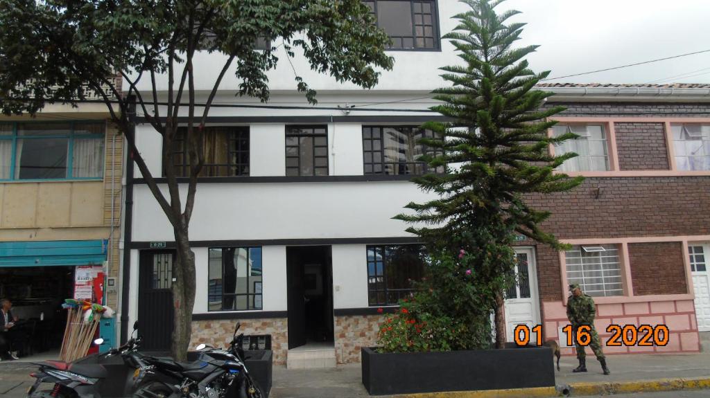 een gebouw met een boom ervoor bij Familia Lombana in Bogota