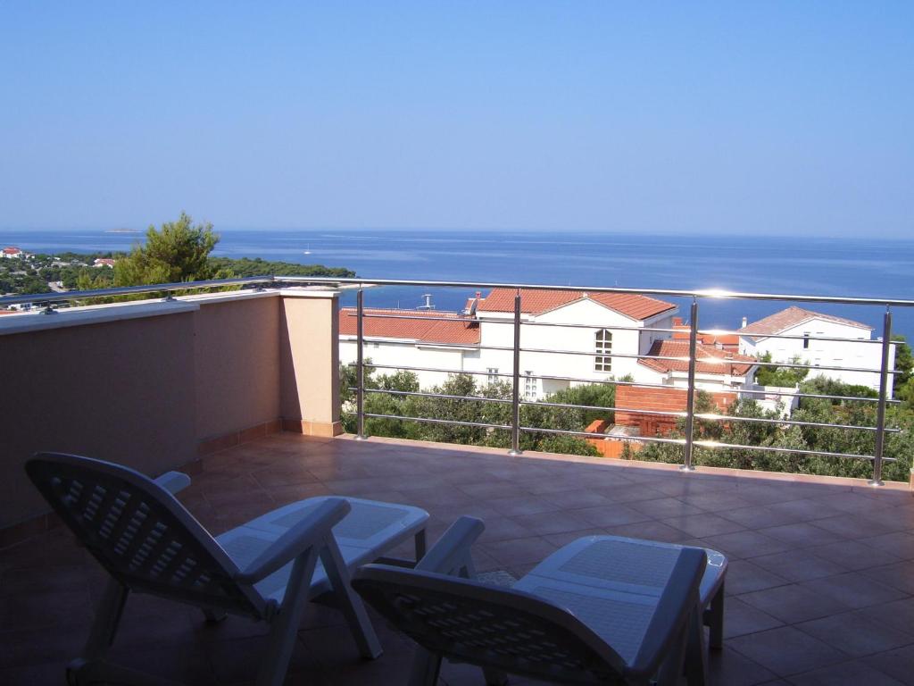 balkon z krzesłami i widokiem na ocean w obiekcie Villa Timea w Primošten