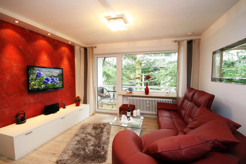 uma sala de estar com uma parede vermelha em Ferienwohnungen Alpentraum - Alpennest 1 und Alpennest 2 em Oberstdorf