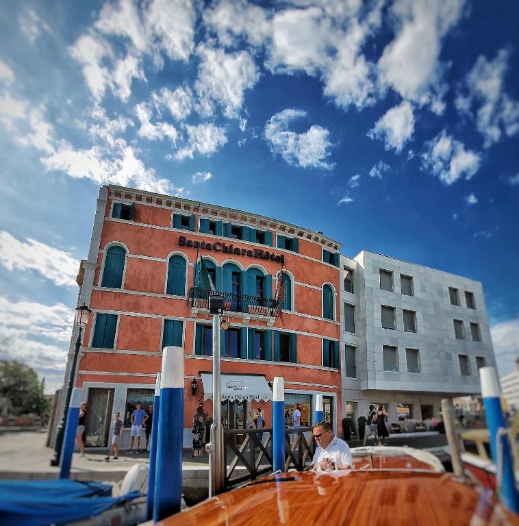 a man is sitting in front of a building at Hotel Santa Chiara in Venice