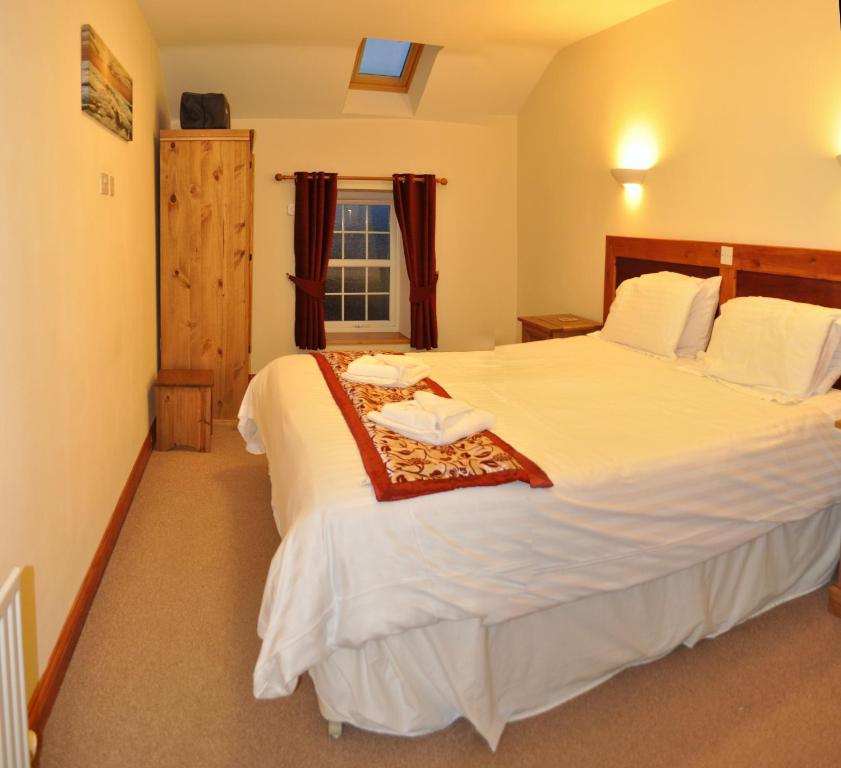 a bedroom with two beds and a window at THE OLD FARMHOUSE in Holmrook