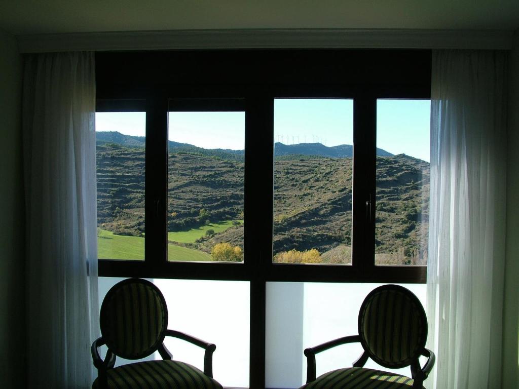 two chairs in front of a window with a view at Vinacua in Sos del Rey Católico