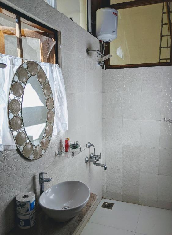 a bathroom with a sink and a mirror at Michèle's Garden in Anjuna