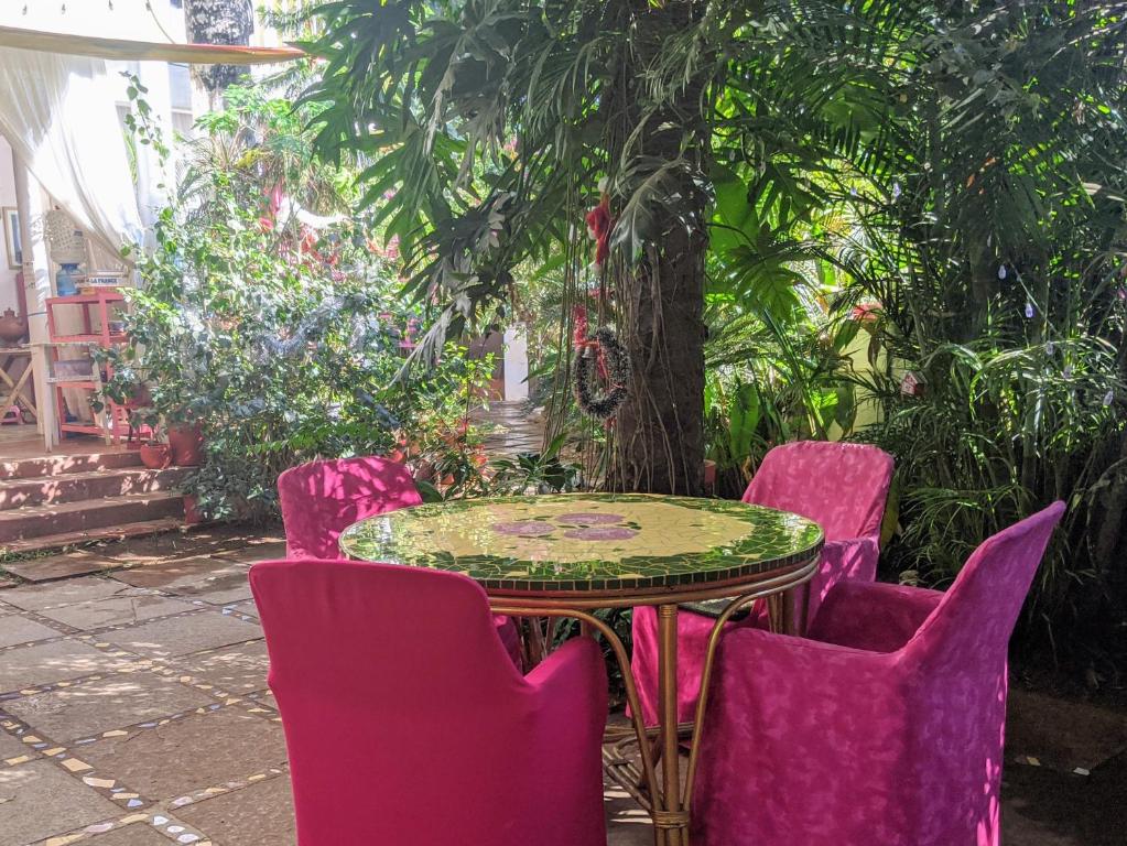 a table and chairs in a garden with a tree at Michèle's Garden in Anjuna