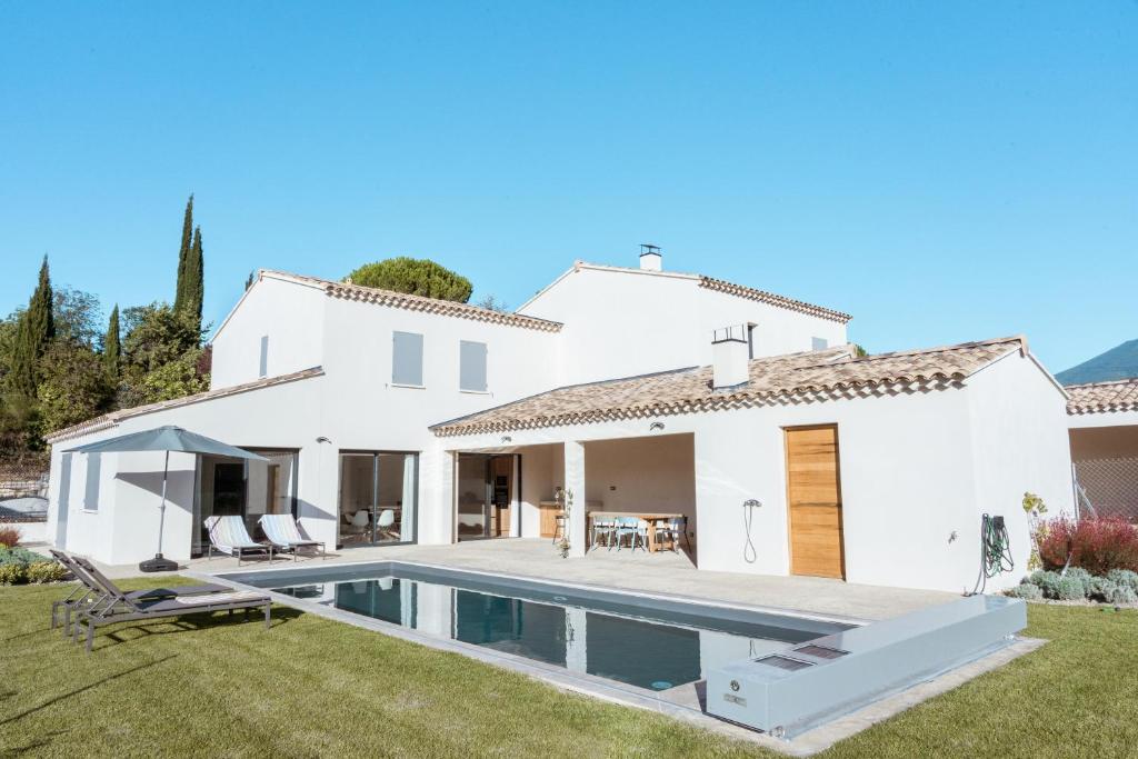 a white villa with a swimming pool in front of it at les palivettes12 in Malaucène