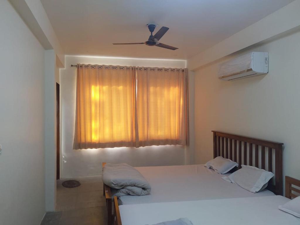 um quarto com 2 camas e uma ventoinha de tecto em TOURIST INN em Jaipur