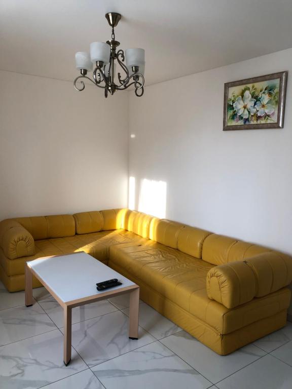 a yellow couch in a living room with a table at LUXflats Rivne in Rivne