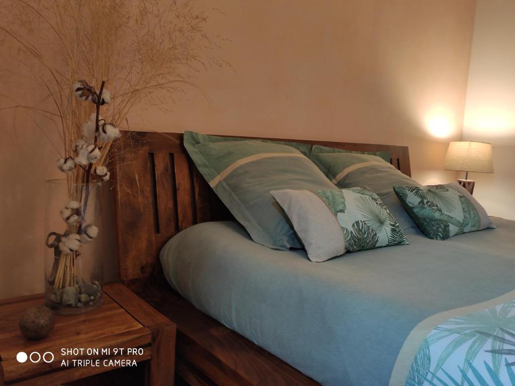 a bedroom with a bed with blue sheets and pillows at Les Prunelliers in Rambouillet