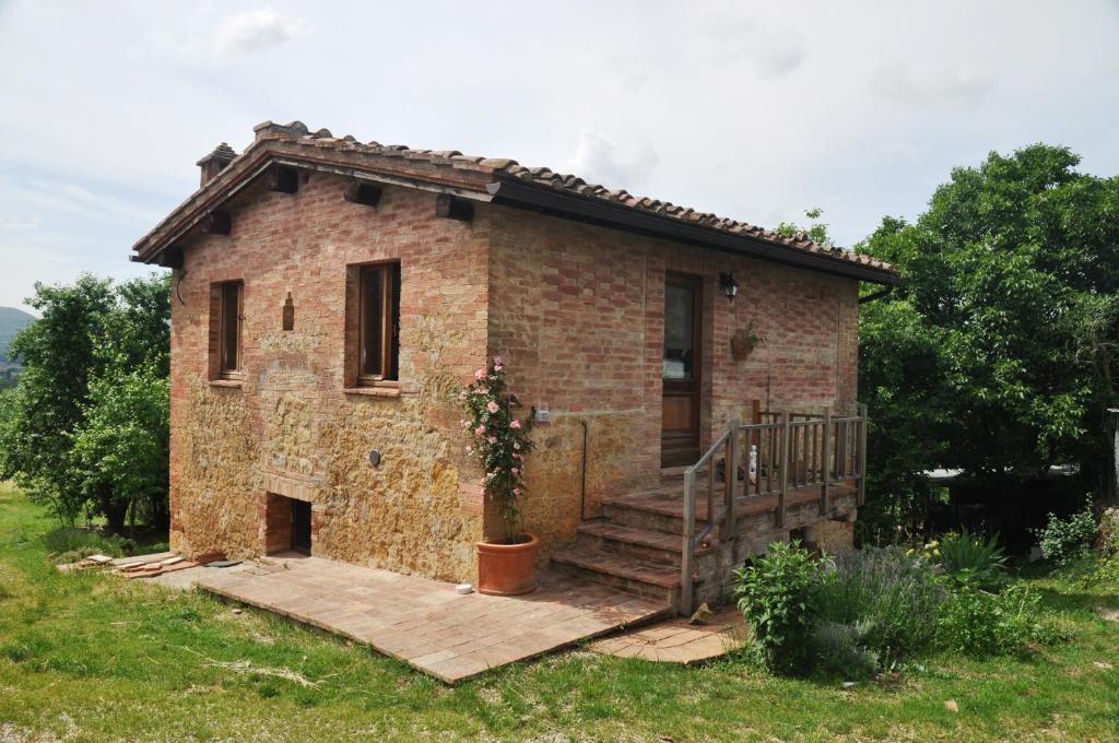 シエナにあるAgriturismo Colombinoの小さなレンガ造りの家(ポーチ付)